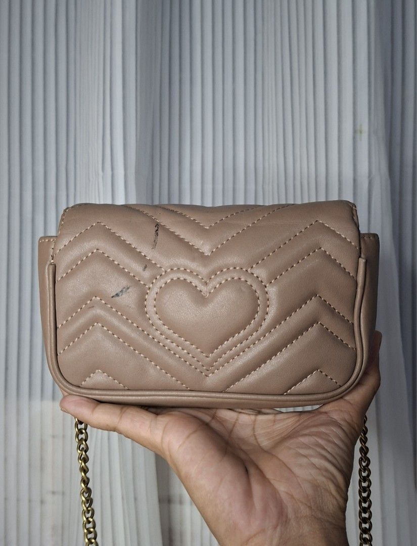 Gucci Marmont Matelassé Mini Bag Beige (Category: Luxury Bags & Wallets) located in Nabua. Submitted by alasaasche36553 (Listing ID 1458023870, Image 3). Description: FREE SF - Cute beige Gucci Marmont mini bag - Gold chain strap - Quilted leather with iconic GG logo - Adorable heart detail on the back - Minor marks on the back (please check photos).