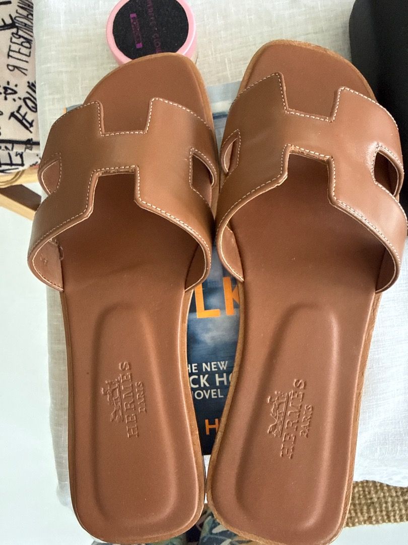 Hermes Oran 38 (Category: Flats & Sandals) located in Makati City. Submitted by eskarina62 (Listing ID 1457956581, Image 1). Description: - Hermes Oran - Classic brown color - Iconic 'H' design - Genuine leather material - Embossed Hermes Paris logo on insole - Ideal for casual wear - Easy slip-on style.