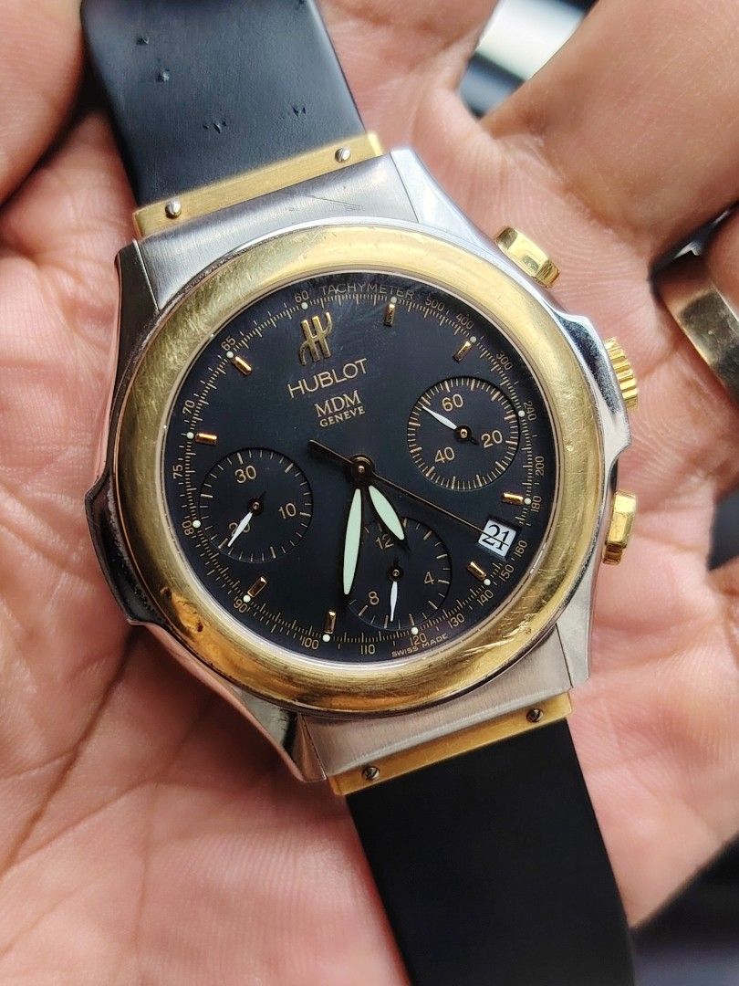 Hublot MDM Geneve Chronograph Two-Tone Watch (Category: Luxury Watches) located in Manila. Submitted by jntwatch03 (Listing ID 1458022849, Image 1). Description: - Hublot MDM Geneve Chronograph Watch - Black dial with gold accents - Tachymeter bezel - Date window - Rubber strap with a two-tone clasp - Swiss Made.