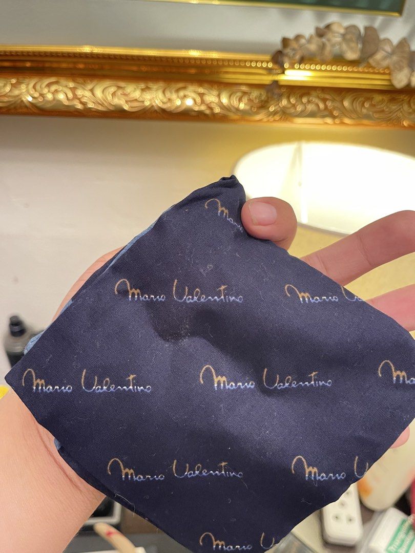 Mario Valentino Navy Blue Handlerchief (Category: Luxury Bags & Wallets) located in Marilao. Submitted by wardrovearchives (Listing ID 1458053502, Image 1). Description: - Navy blue pocket square - Features repeating Mario Valentino logo - Includes light blue stripes on one side - Note: Has a small stain - Ideal accessory to elevate your suit.