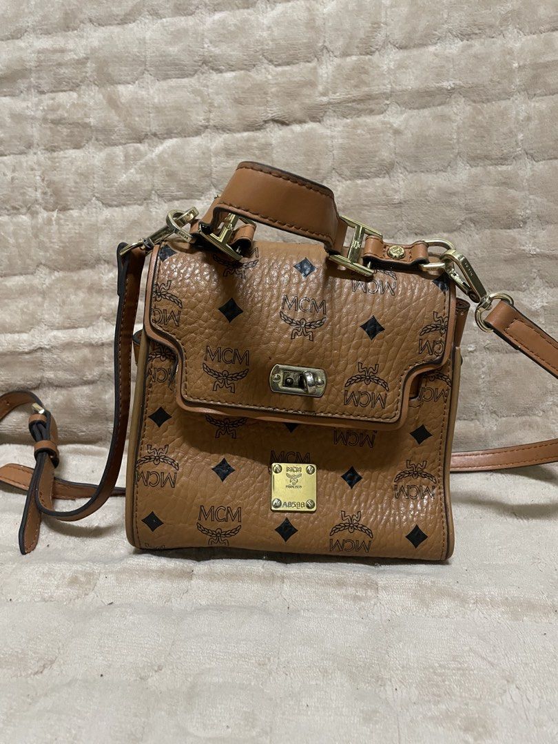 MCM cognac-colored mini satchel (Category: Luxury Bags & Wallets) located in Caloocan City. Submitted by vntgxlocalsph (Listing ID 1458062986, Image 1). Description: dents on pic.