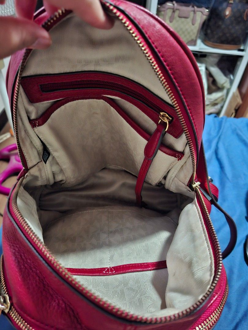 Michael Kors Red Leather Studded Backpack (Category: Backpacks) located in Manila. Submitted by yanakolekzione (Listing ID 1458063864, Image 3). Description: - Authentic Michael Kors backpack in a striking red color. - Crafted from genuine leather with elegant gold stud accents on zippers. - Interior boasts multiple compartments, including a secure zippered pocket. - Adjustable straps for a comfortable, customized fit. - Please note: Minor signs 