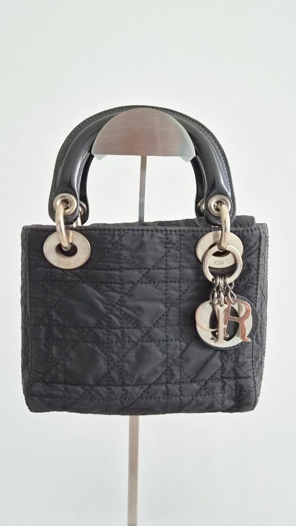 Mini Lady Dior Nylon (Category: Luxury Bags & Wallets) located in Manila. Submitted by declutterwithme__ (Listing ID 1457959595, Image 1). Description: - Authentic Christian Dior Lady Dior Bag - Color: Black - Material: Quilted Nylon - Features: Iconic Dior Charms, Patent Leather Handle - Interior: Clean - Hardware: Shows some signs of wear - Condition: Classic piece, well-loved - Inclusion: original strap please note bag is vintage style Price i