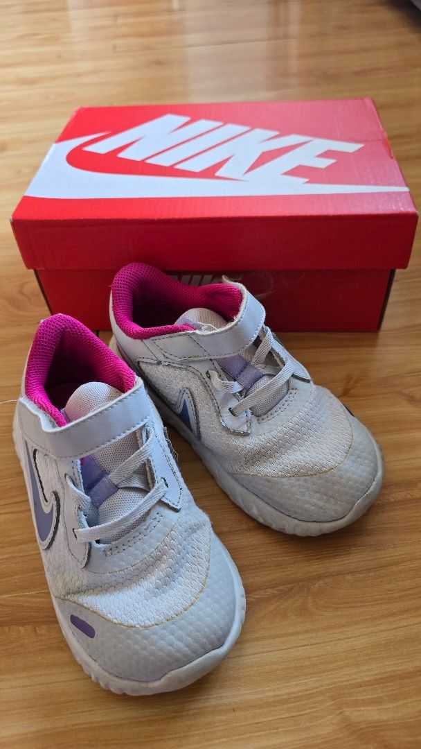Nike Kids' Sneakers (Category: Babies & Kids Fashion) located in Quezon City. Submitted by impdc1130 (Listing ID 1458080935, Image 1). Description: Light grey Nike kids' sneakers, size 10C. Features pink lining and purple swoosh..