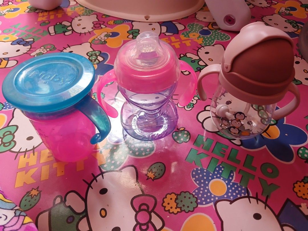 Nuby Sippy Cups and Baby Bottle (Category: Weaning & Toddler Feeding) located in Manila. Submitted by pretty0099 (Listing ID 1457923482, Image 2). Description: - Set of baby feeding items - Includes Nuby sippy cup with blue lid and handles - Pink and purple baby bottle with nipple - Clear bottle with pink lid and straw - All bottles/cups feature handles for easy gripping - Ideal for transitioning your baby from bottle feeding to cup drinking.