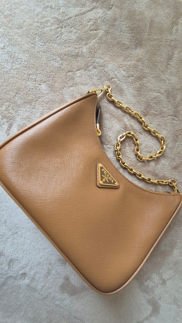 UNUSED: Prada Re-Edition (Category: Luxury Bags & Wallets) located in Makati City. Submitted by shop_at_my_cart (Listing ID 1457919727, Image 3). Description: - Authentic Prada re edition bag - Color: Caramel Brown - Material: Saffiano Leather - Includes: Dust bag, authenticity card, strap, chain,purse - Ideal for carrying essentials.