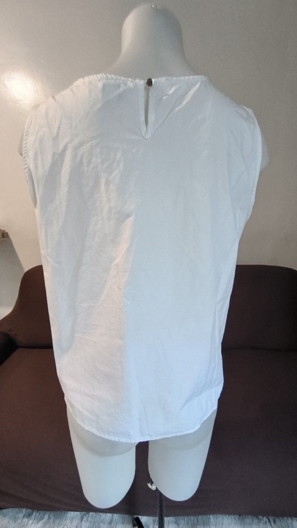 White Sleeveless Top with Ruffle Detail (Category: Sleeveless) located in Antipolo. Submitted by secondcharmstore (Listing ID 1457981845, Image 3). Description: -size: XL -chest: 40-42 inches -length: 23 inches - White sleeveless top - Features a cute ruffle detail down the front - Round neckline - Button closure at the back - Simple and chic design - Versatile for casual wear or dressing up.