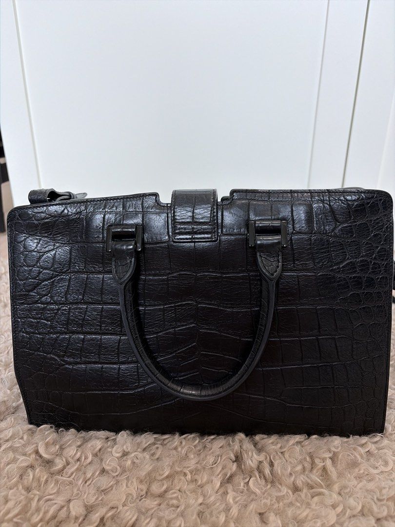 YSL Saint Laurent Monogram Cabas Bag （分類：手袋及銀包）位於 Hong Kong。 由 luxurystyles 提交（商品編號 1457950236，圖片 2）。簡介： Product Information This elegant Cabas tote from Saint Laurent is ideal for everyday use. Crafted from croc-embossed leather, the bag is detailed with a black-tone YSL motif snap closure, dual-rolled handles and protective metal feet at the bottom. It opens to a spacious suede-lined interior that houses a well-sized compartment to hold all you