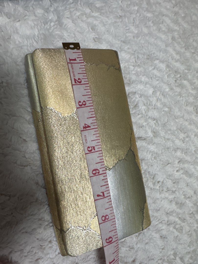 2027 Gold Brocade Clutch Bag with Abstract Pattern (Category: Clutches) located in Silang. Submitted by sari2bilina (Listing ID 1458231128, Image 2). Description: - Stunning gold brocade clutch bag - Features a beautiful abstract pattern in gold and silver tones - Interior lined in gold fabric - Includes a convenient pleated compartment - Secure snap button closure - Approximate dimensions: 8 inches long x 4 inches tall - Ideal for evening wear a