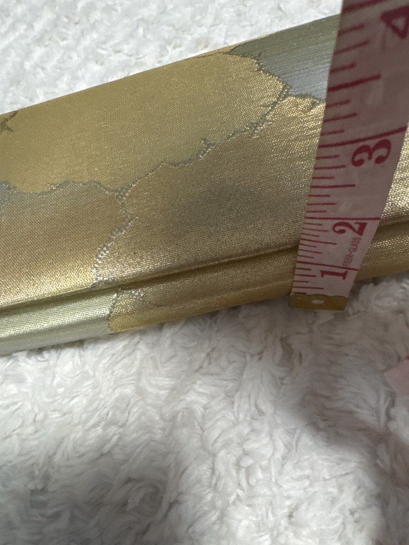 2027 Gold Brocade Clutch Bag with Abstract Pattern (Category: Clutches) located in Silang. Submitted by sari2bilina (Listing ID 1458231128, Image 3). Description: - Stunning gold brocade clutch bag - Features a beautiful abstract pattern in gold and silver tones - Interior lined in gold fabric - Includes a convenient pleated compartment - Secure snap button closure - Approximate dimensions: 8 inches long x 4 inches tall - Ideal for evening wear a