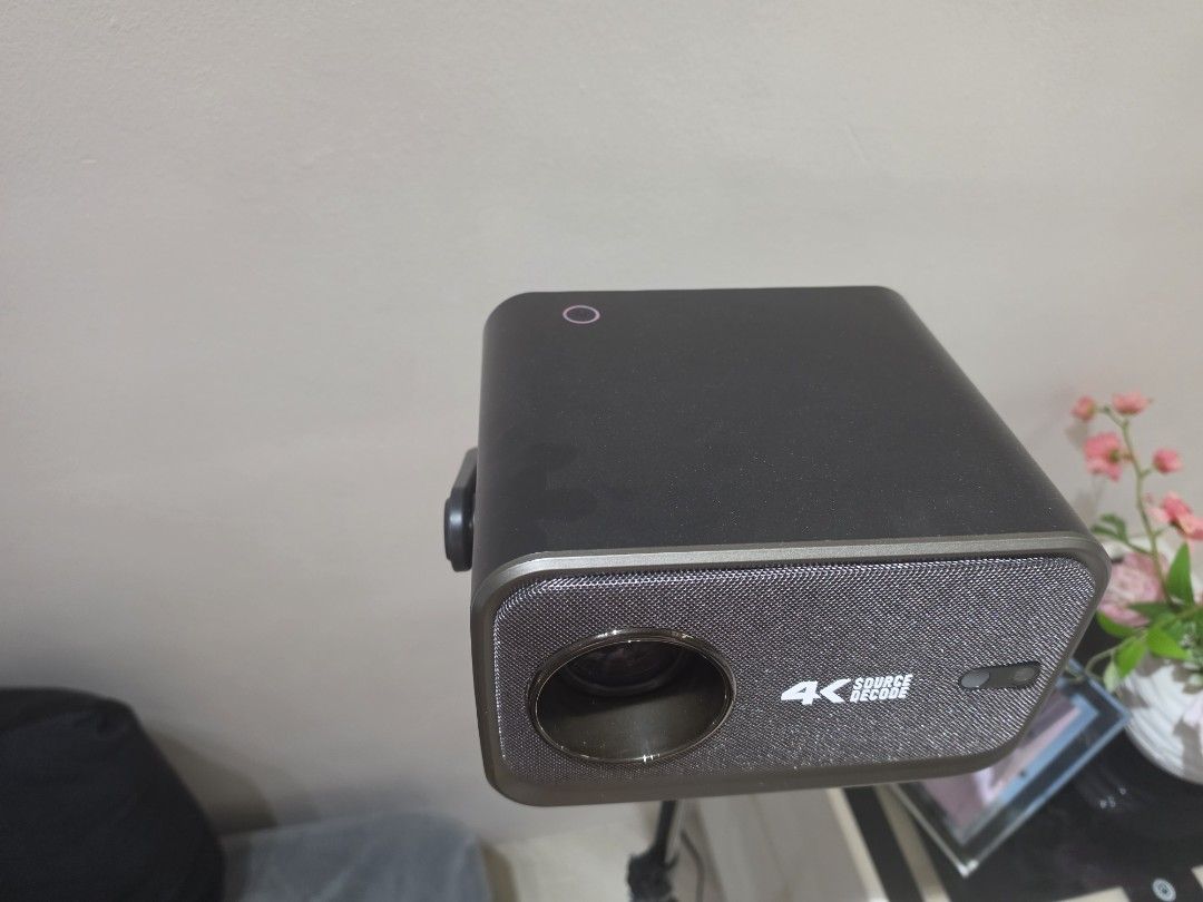 4K Source Decode Projector (Category: Projectors) located in Singapore. Submitted by lippyboy79 (Listing ID 1458170459, Image 2). Description: - Compact projector with 4K source decode capability 6500 ansi lumens - Ideal for home entertainment small and compact - Clear lens cabable to watch in daylight - Dark grey unit with textured speaker grille - android 13 comes with playstore youtube netflix - free stand to hold projector.