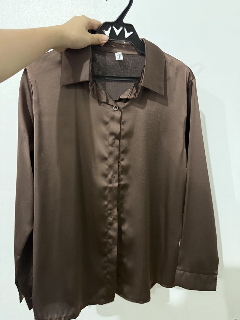 Brown Satin Button-Up Shirt (Category: Shirts) located in Batangas. Submitted by misscalista_ (Listing ID 1458210472, Image 1). Description: - Classic brown satin shirt - Button-up front with collar - Long sleeves - Features a subtle sheen - Perfect for casual or formal wear - Pairs well with jeans or trousers.