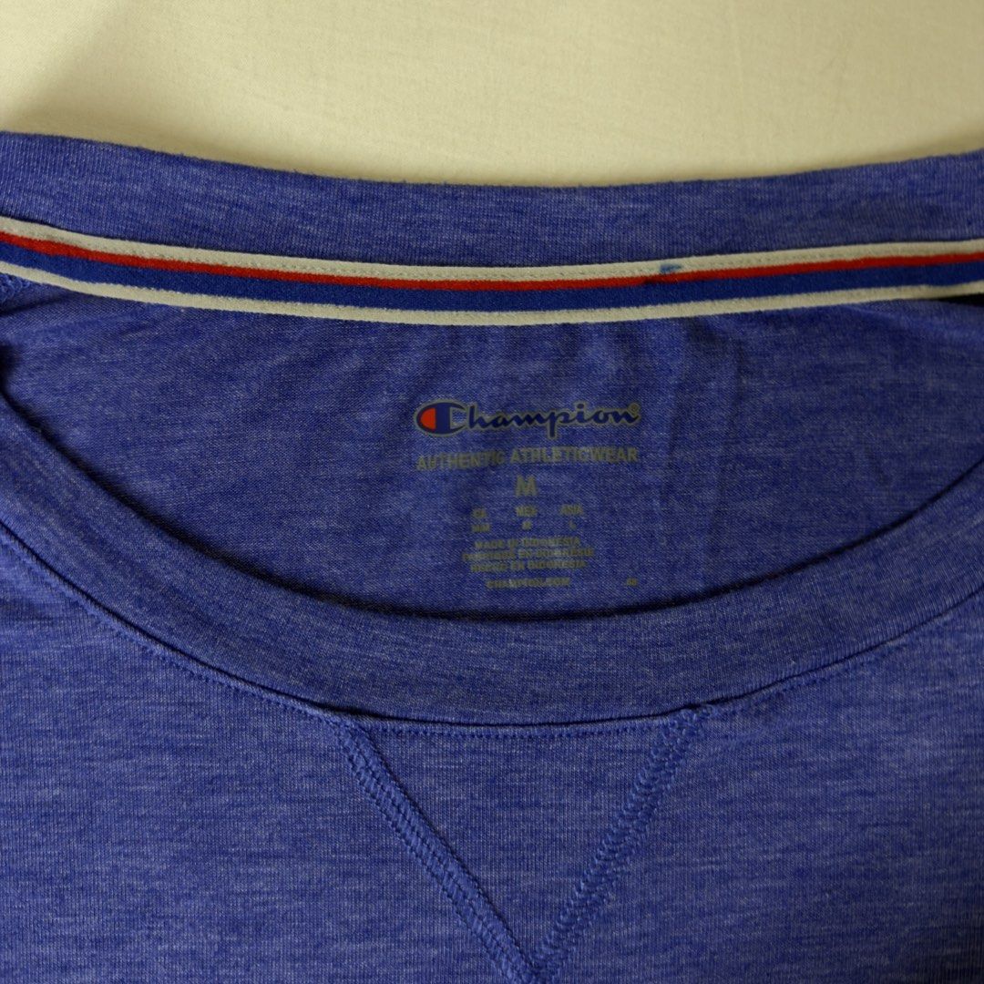 Champion Blue T-Shirt Size M (Category: Shirts) located in Angeles City. Submitted by muse_archive (Listing ID 1458172332, Image 2). Description: - Champion T-Shirt - Color: Blue with Black Sleeves - Size: Medium (M) - Features: Heathered fabric texture, blue and light blue stripes on sleeves - Style: Casual wear or sports - Fit: Comfortable.