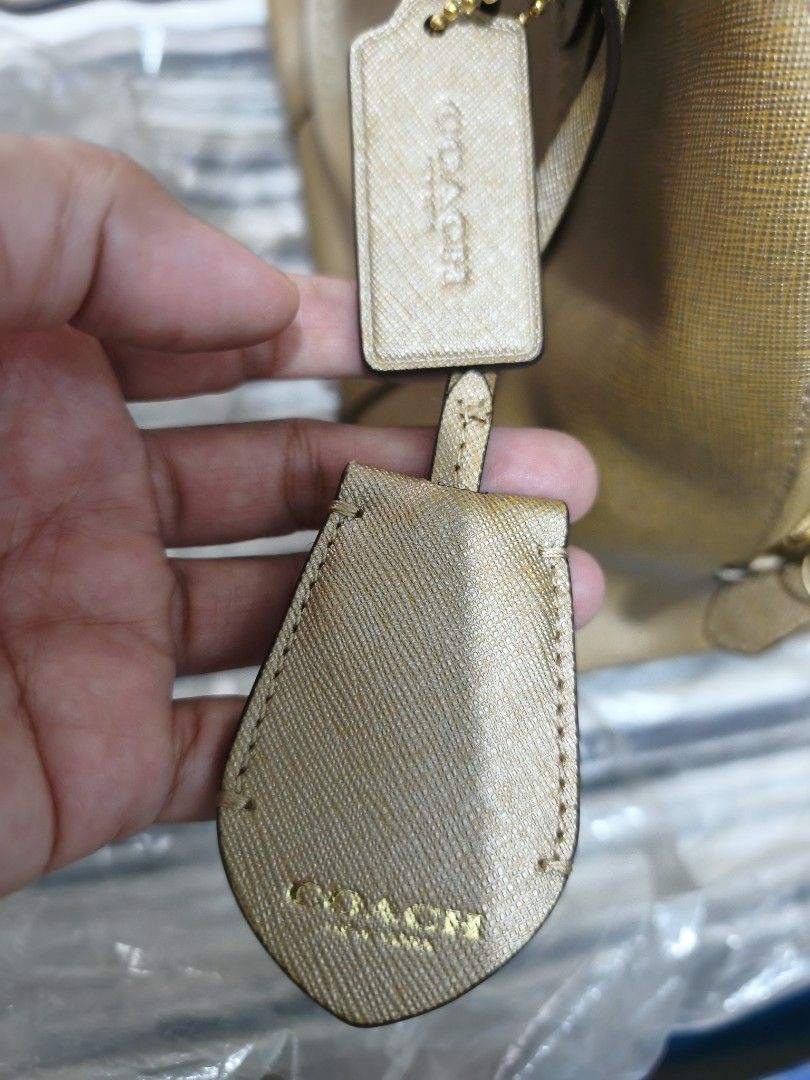 Coach Gold Textured Leather Satchel Bag (Category: Shoulder Bags) located in Quezon City. Submitted by tajima (Listing ID 1458101822, Image 3). Description: - Authentic Coach gold textured leather satchel bag - Features signature Coach hangtag - Protective metal feet on the bottom - Secure top zipper closure - Two comfortable top handles - Convenient front slip pocket - Ideal for everyday use.