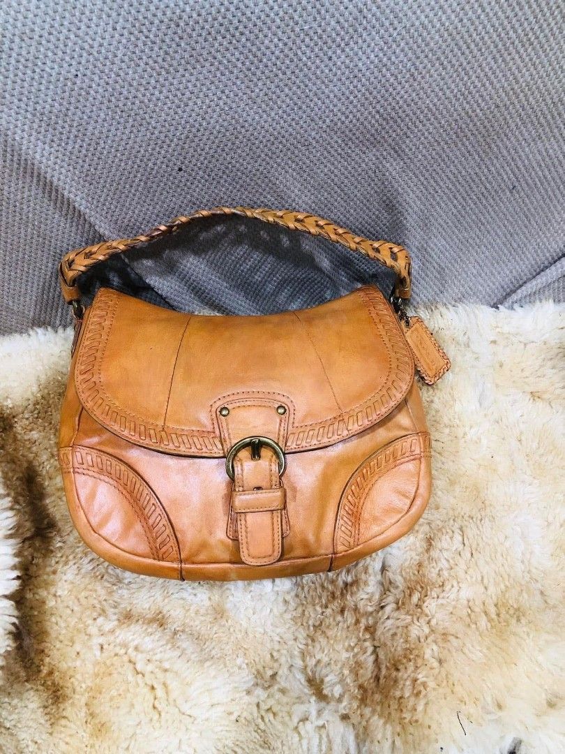 Coach Leather Hobo Shoulder Bag Tan (Category: Luxury Bags & Wallets) located in Cainta. Submitted by riszizlux (Listing ID 1458232458, Image 2). Description: - Genuine tan leather Coach hobo bag - Stylish braided strap detail - Secure buckle closure on front flap - Vibrant red interior lining - Durable YKK zipper - Spacious main compartment for essentials - Timeless Coach design.