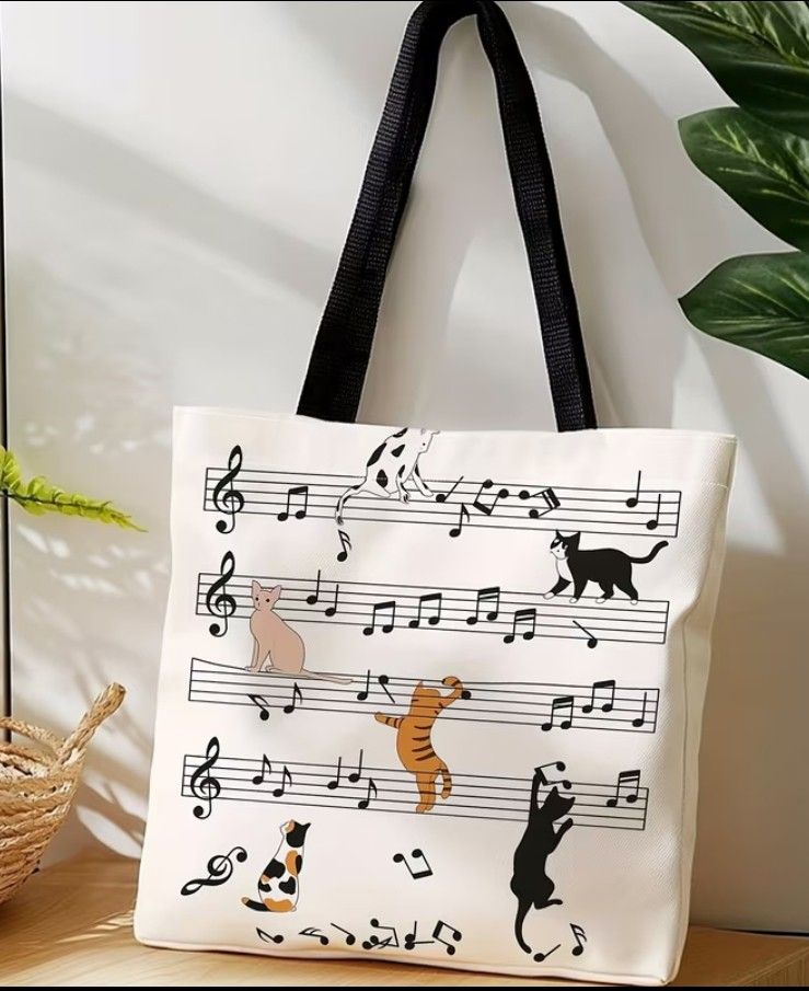 Cute Cat Music Notes Tote Bag (Category: Tote Bags) located in Mariveles. Submitted by adhes28 (Listing ID 1458203705, Image 1). Description: - Adorable white tote bag featuring a fun print of cats playing on musical notes. - Sturdy black straps for comfortable carrying. - Ideal for everyday use, carrying your essentials. - A must-have for cat lovers and music enthusiasts! - Approximate dimensions: 15 inches tall x 13 inches wide..