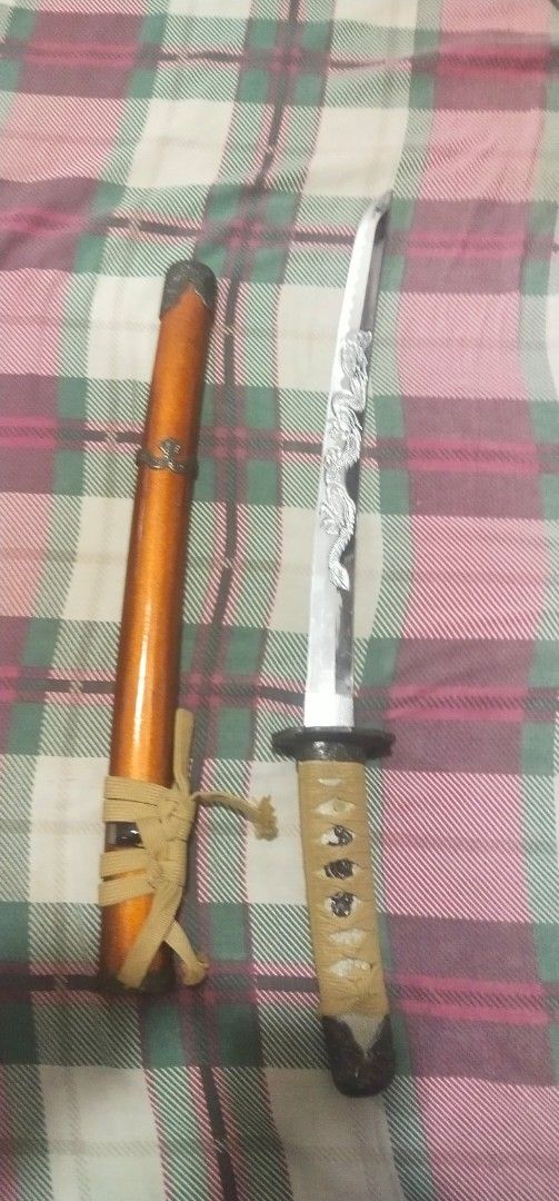 Decorative Katana Sword with Scabbard (Category: Vintage Collectibles) located in Muntinlupa City. Submitted by grayfox05 (Listing ID 1458149960, Image 3). Description: - Decorative katana sword, ideal for display. - Features a glossy orange finished wooden scabbard. - Handle is wrapped in tan cord for a comfortable grip. - Blade includes intricate decorative etching. - Comes with a tie to securely fasten the sword in the scabbard. meet up bayana