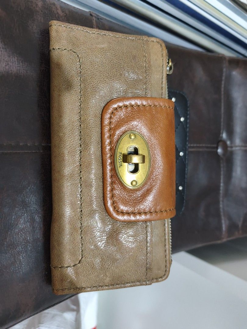 Fossil Leather Wallet (Category: Wallets & Card holders) located in Quezon City. Submitted by tajima (Listing ID 1458159209, Image 1). Description: - Genuine brown leather Fossil wallet - Secure turn-lock closure on front flap - Convenient zip pocket on the back - Multiple interior card slots - Clear ID window for easy access - Unique key pattern lining - Shows some signs of wear, still fully functional.