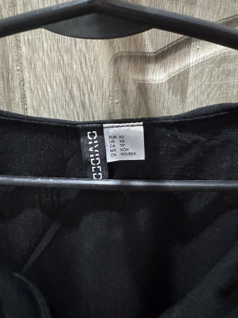 H&M Black Tie Front Ruffle Top (Category: Sleeveless) located in Calamba. Submitted by nicalison (Listing ID 1458231079, Image 2). Description: - Black crop top from Divided - Short sleeves with ruffle details - Tie front closure - Ruffle trim along neckline and hem - Feels like a linen blend - Super cute and breezy for summer.