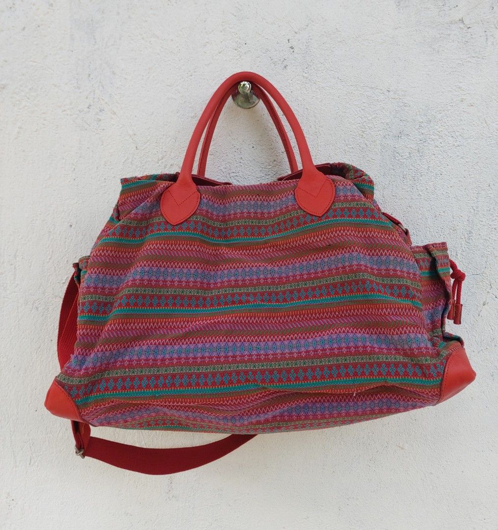 Kenzo Boston Travel bag (Category: Luxury Bags & Wallets) located in Lapu Lapu. Submitted by agnesapm_29813 (Listing ID 1458224500, Image 2). Description: - Authentic Kenzo bag - Colorful striped pattern woven bag - Red leather trim and handles - With shoulder strap - Spacious interior for essentials - Ideal for travel or everyday use - Unique and eye-catching design - With slight signs of usage - Measurements: 18 inches x 13 inches x 10 inches .