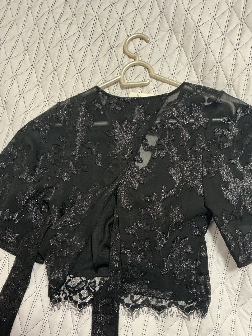Miss Selfridge Shimmery Laced Top (Category: Blouses) located in Makati City. Submitted by boldturtle-8720 (Listing ID 1458189679, Image 3). Description: This is a Miss Selfridge black short-sleeve crop top with shimmery floral burnout or devoré pattern, a V-neckline, and a tie-back hem accented with lace detailing. Shoulder 13in Bust 14in Length 16in.