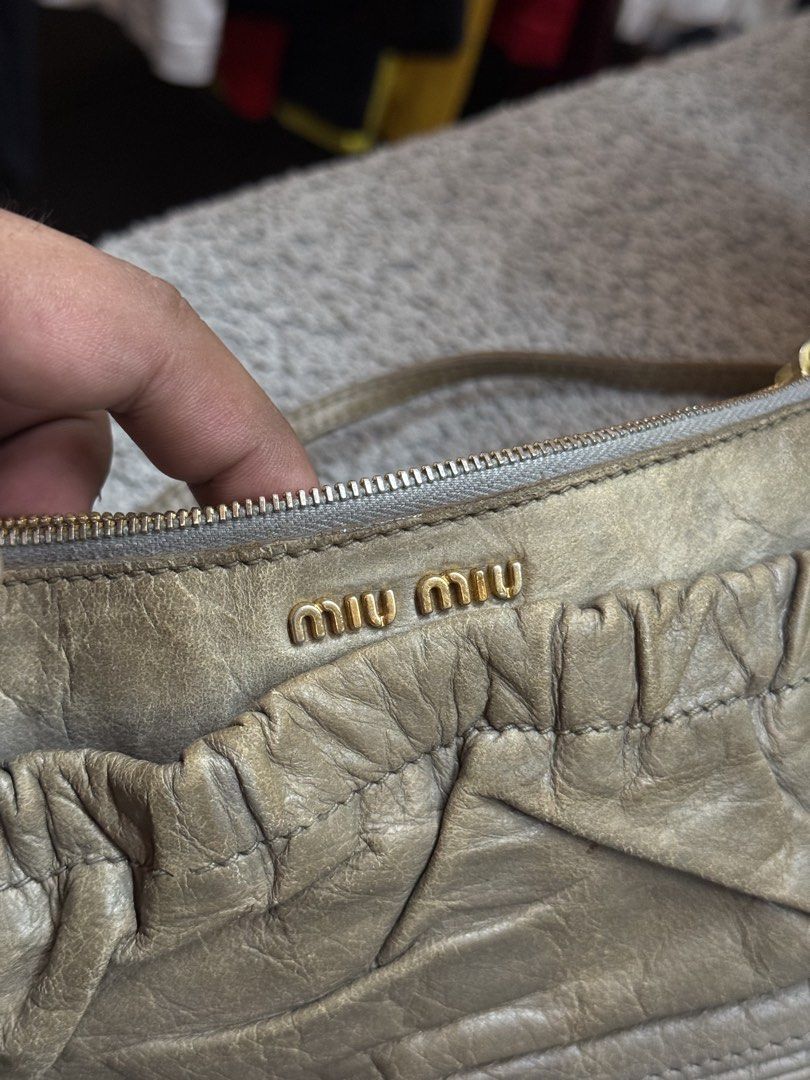 Miu Miu Leather Shoulder Bag (Category: Luxury Bags & Wallets) located in Legazpi City. Submitted by deadthrift (Listing ID 1458182971, Image 2). Description: - Authentic Miu Miu Bag - Color: Taupe/Greyish Leather - Design: Ruched front detail - Hardware: Gold - Includes: Cute charm - Origin: Made in Turkey.