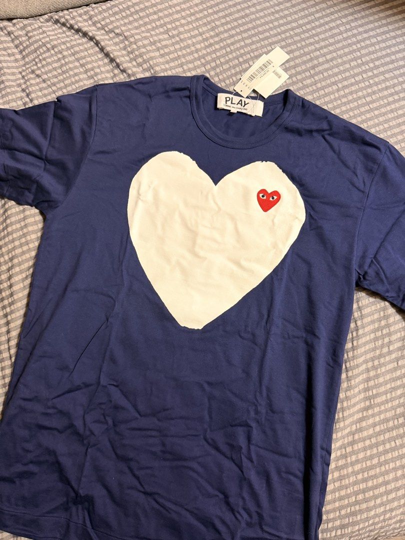 Play CDG Comme des Garcons (Category: Tshirts & Polo Shirts ) located in Pasig City. Submitted by donmsamson (Listing ID 1458269482, Image 1). Description: - Brand: Play CDG Comme des Garcons - Color: Navy Blue - Size: XXL - Design: Iconic heart logo with red eyes and large white heart graphic - Condition: Brand New - Style: Streetwear, casual.