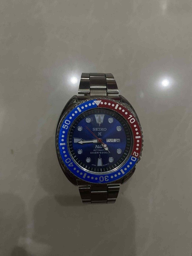 Seiko Automatic Diver's 200m Watch (Category: Men's Watches) located in Caloocan City. Submitted by cadalojohn65897 (Listing ID 1458152877, Image 1). Description: - Seiko Automatic Watch - Striking blue dial with a red and blue bezel - Convenient day and date function - Water resistant up to 200 meters, ideal for diving - Durable stainless steel strap - Reliable Japan movement - Versatile for both diving adventures and everyday wear.
