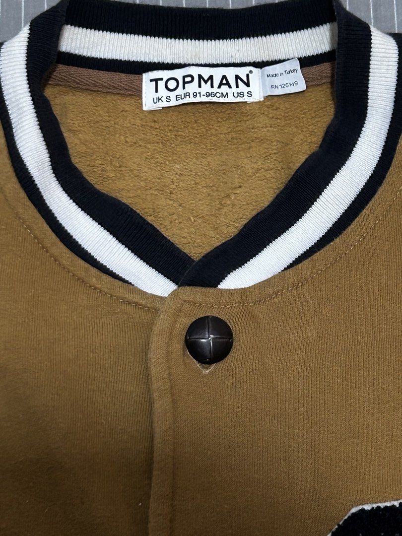 Topman Varsity Jacket Brown "G" Letterman Style (Category: Coats, Jackets and Outerwear) located in Dinalupihan. Submitted by sty11sh (Listing ID 1458284185, Image 2). Description: - Brown varsity jacket from Topman - Cream sleeves with striped trim - Large 'G' patch on chest - Button-up front - Made in Turkey.