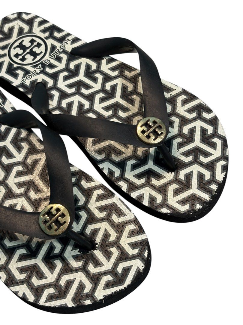 Tory Burch Logo Pattern Flip Flops (Category: Slippers and slides) located in Cagayan de Oro. Submitted by initingfinds (Listing ID 1458260533, Image 3). Description: Authentic Tory Burch monogram rubber flip flop sandals in black and white geometric print. Features matte black rubber thong straps with signature gold-toned Double T metallic logo medallions. Outsoles feature debossed logo grid pattern. Inner strap includes molded origin markings. 