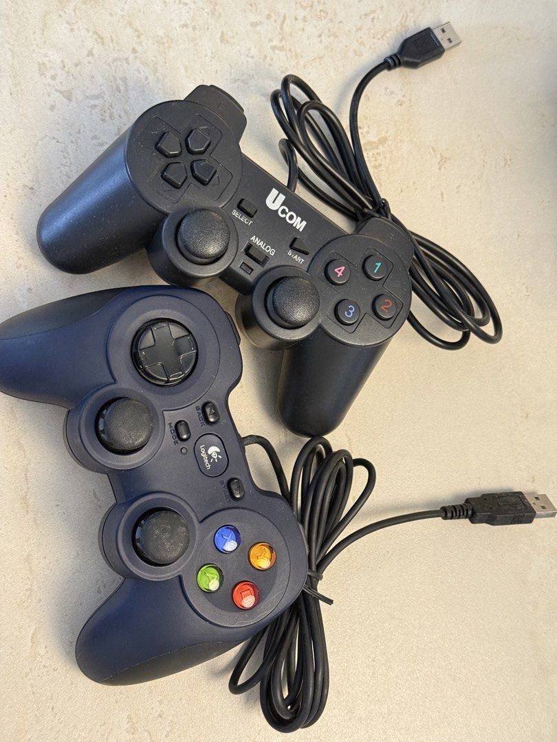 2x USB PC Game Controllers - Logitech & UCOM (Category: Controllers) located in Cheras. Submitted by rewsim (Listing ID 1458355421, Image 1). Description: - Two USB PC game controllers available. - Includes one blue Logitech controller. - Includes one black UCOM controller. - Both controllers are wired. - Tested and confirmed working. - Perfect for enhancing your PC gaming experience..