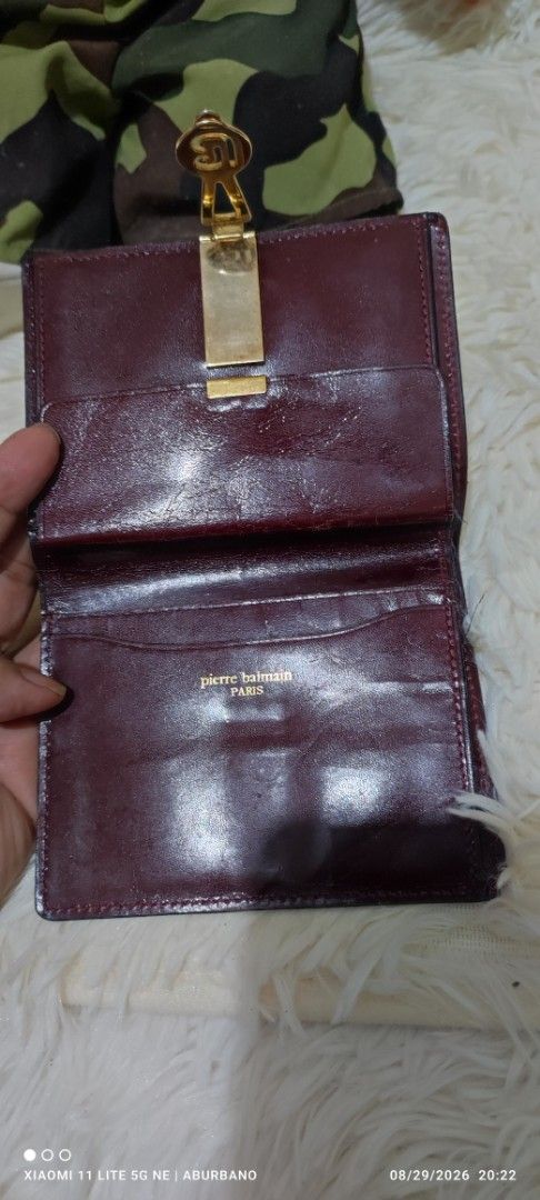 Balmain Bi-fold Wallet (Category: Wallets & Card holders) located in Makati City. Submitted by yerbua103 (Listing ID 1458429775, Image 3). Description: This is a vintage Balmain wallet with a gold-tone clasp closure in burgundy color. It has tonal stitched borders and a distinctive logo accent on the front flap. Manage your expectations as you're buying a preloved/ukay wallet. Disclaimer: No copyright/ infringement is intended. the brand belongs 