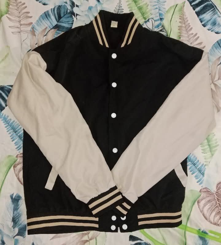 Black and Cream Varsity Jacket (Category: Coats, Jackets and Outerwear) located in Manila. Submitted by goldie.lockes (Listing ID 1458359613, Image 1). Description: - Classic black and cream varsity jacket - Ribbed collar, cuffs, and hem with stripe details - Button-up front - Ideal for layering - Pairs well with jeans or joggers - A cool wardrobe staple Price is negotiable.