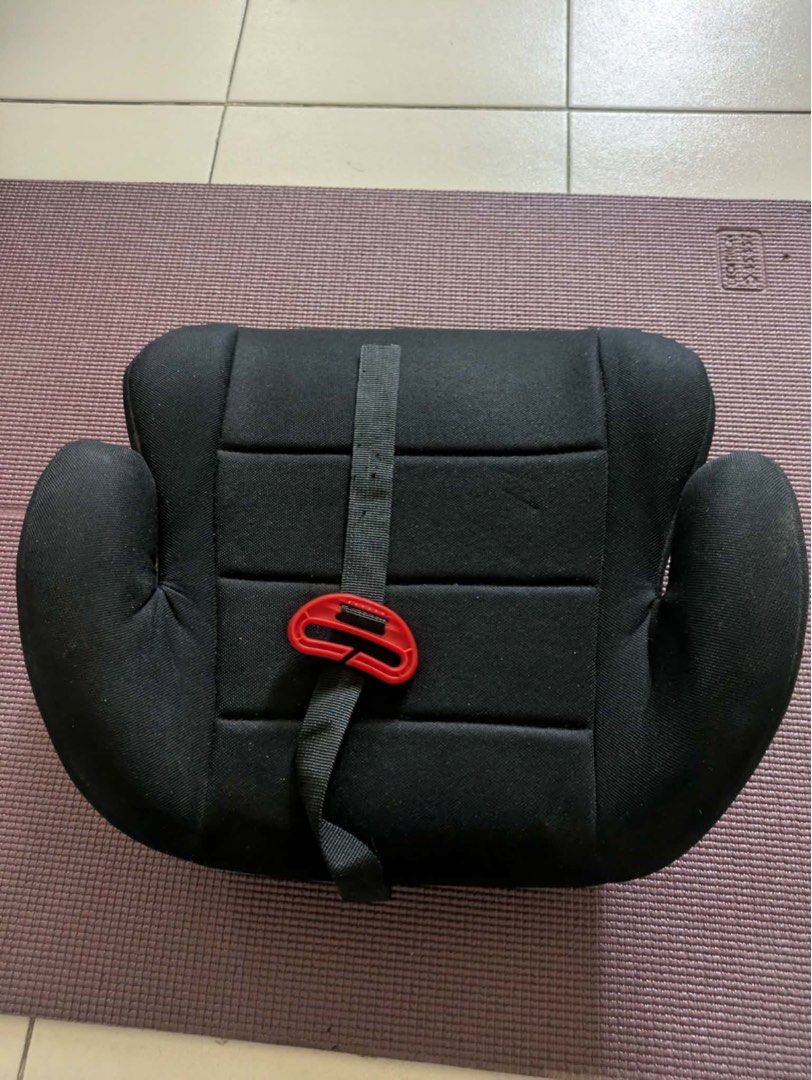 Black Car Seat Booster with Strap (Category: Car Seats) located in Quezon City. Submitted by jessiemarketplace (Listing ID 1458323848, Image 1). Description: - Black car seat booster for child safety. - Features a secure strap with a red clip. - Padded sides offer extra comfort during rides. - Durable hard plastic base for stability. - Simple and easy installation process. - Ensures a safe journey for your child..