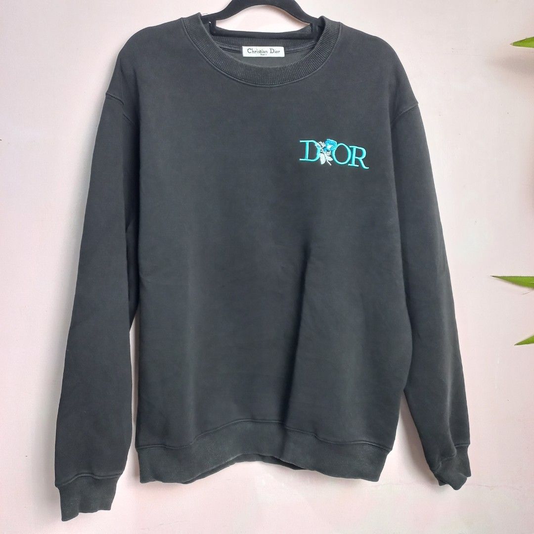 Christian Dior Crewneck Sweatshirt (Category: Others Tops) located in Naga. Submitted by whimsy_vault (Listing ID 1458312631, Image 1). Description: Christian Dior crewneck sweatshirt featuring a teal embroidered "DIOR" logo with a blue floral graphic replacing the letter "I". FLAT LAY MEASUREMENTS (Approximate): • Pit to Pit: 23 inches • Length (Shoulder to Hem): 26 inches.