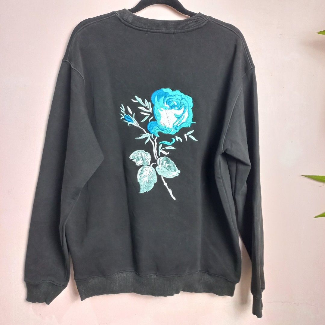 Christian Dior Crewneck Sweatshirt (Category: Others Tops) located in Naga. Submitted by whimsy_vault (Listing ID 1458312631, Image 2). Description: Christian Dior crewneck sweatshirt featuring a teal embroidered "DIOR" logo with a blue floral graphic replacing the letter "I". FLAT LAY MEASUREMENTS (Approximate): • Pit to Pit: 23 inches • Length (Shoulder to Hem): 26 inches.