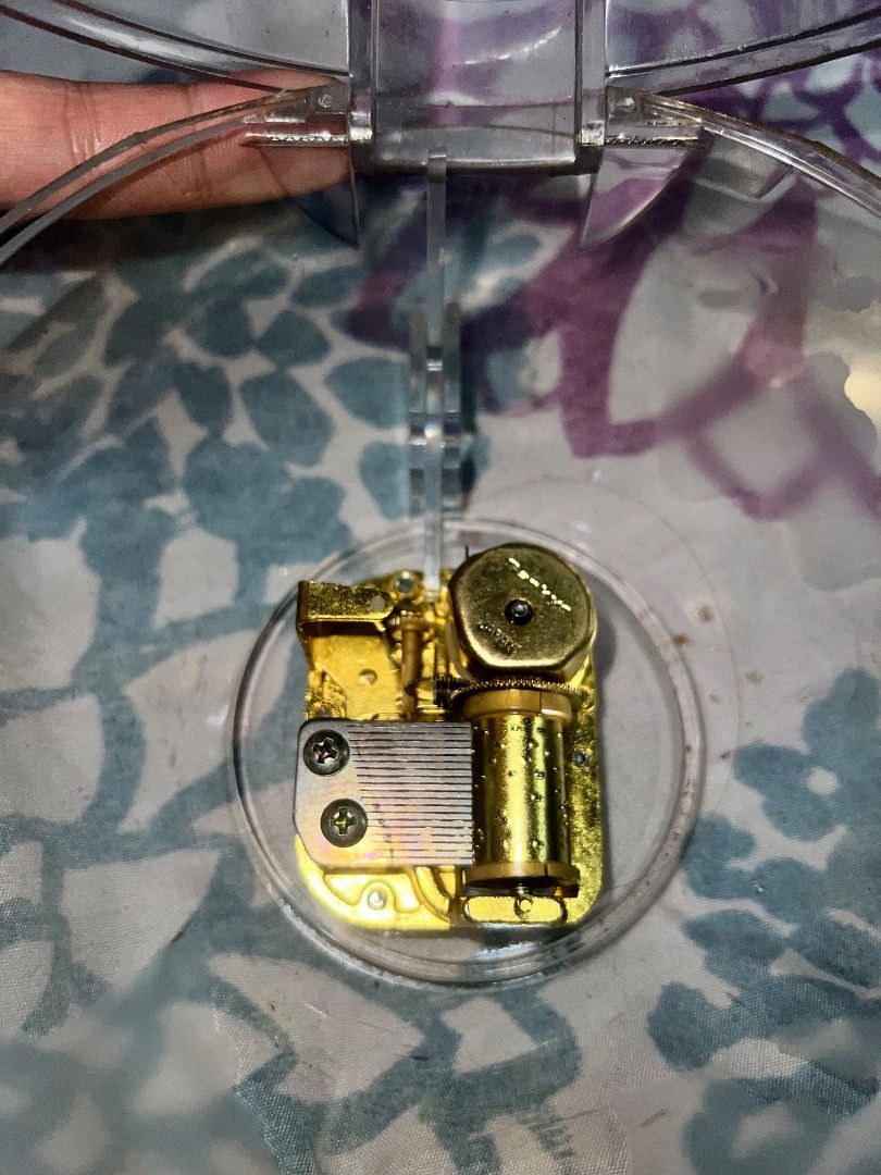 Clear Music Box Mechanism with Gold Components (Category: Accessory Holder, Box & Organizers) located in Caloocan City. Submitted by joshualari57872 (Listing ID 1458345975, Image 1). Description: - Gold-colored music box mechanism - Housed in a clear plastic casing - Features a clear, hinged plastic lid - Inner workings are visible for a unique aesthetic - Ideal for DIY crafts, custom music boxes, or decorative projects Offer na kayo.
