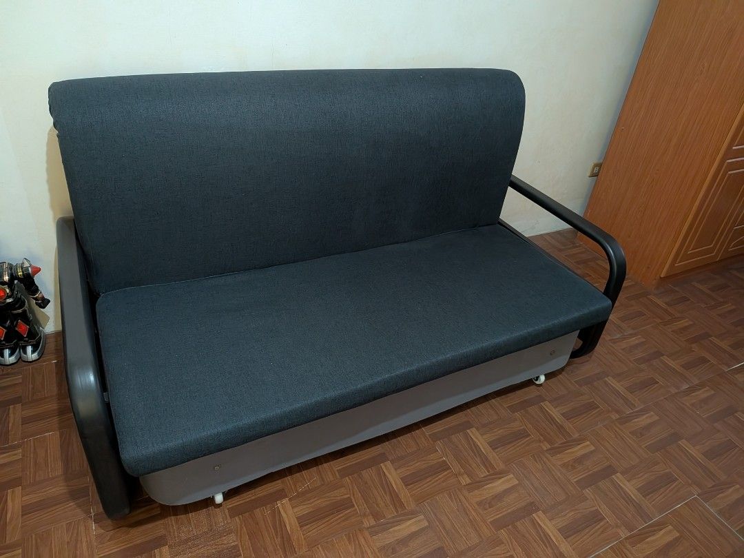 Dark Grey Sofa Bed - Converts to Bed (Category: Sofas) located in Caloocan City. Submitted by taga.earth (Listing ID 1458435867, Image 2). Description: - Versatile dark grey fabric sofa bed - Easily converts from sofa to flat bed - Ideal for small spaces or guest rooms - Sturdy frame with metal armrests - Features wheels for easy mobility - Minor signs of use, good overall condition.