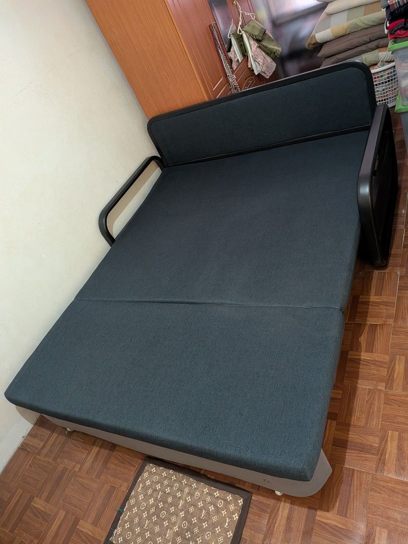 Dark Grey Sofa Bed - Converts to Bed (Category: Sofas) located in Caloocan City. Submitted by taga.earth (Listing ID 1458435867, Image 3). Description: - Versatile dark grey fabric sofa bed - Easily converts from sofa to flat bed - Ideal for small spaces or guest rooms - Sturdy frame with metal armrests - Features wheels for easy mobility - Minor signs of use, good overall condition.