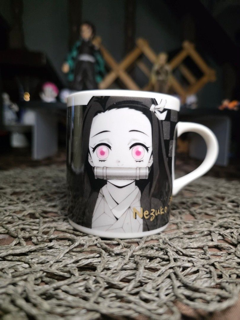 Demon Slayer Nezuko Monochrome Mug Aniplex (Category: Coffee & Tea Tableware) located in Zamboanga. Submitted by lunavinum (Listing ID 1458445302, Image 2). Description: - Demon Slayer Nezuko Mug - Monochrome design featuring Nezuko's face - Checkered pattern with gold accents on the other side - Microwave and dishwasher safe - Comes in its original box - Ideal gift for any anime fan.
