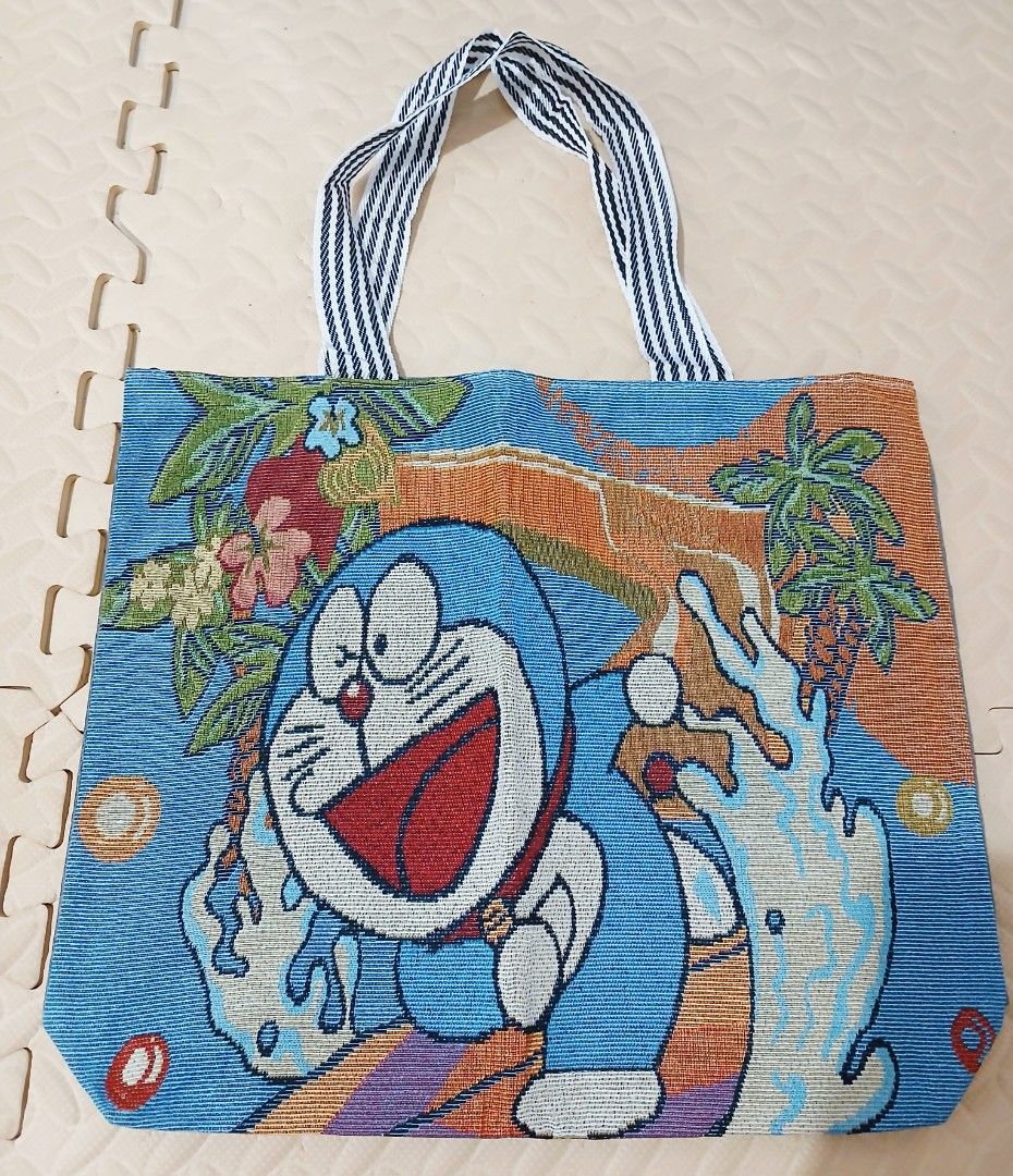 Doraemon Tote Bag (Category: Tote Bags) located in Calamba. Submitted by BraidApparel (Listing ID 1458340596, Image 1). Description: - Adorable Doraemon tote bag - Vibrant design on the front - Plain grey back - Interior zippered pocket for essentials - Striped handles for a stylish touch - Ideal for everyday use or as a thoughtful gift Location: Calamba City Laguna Deliver via J&T .
