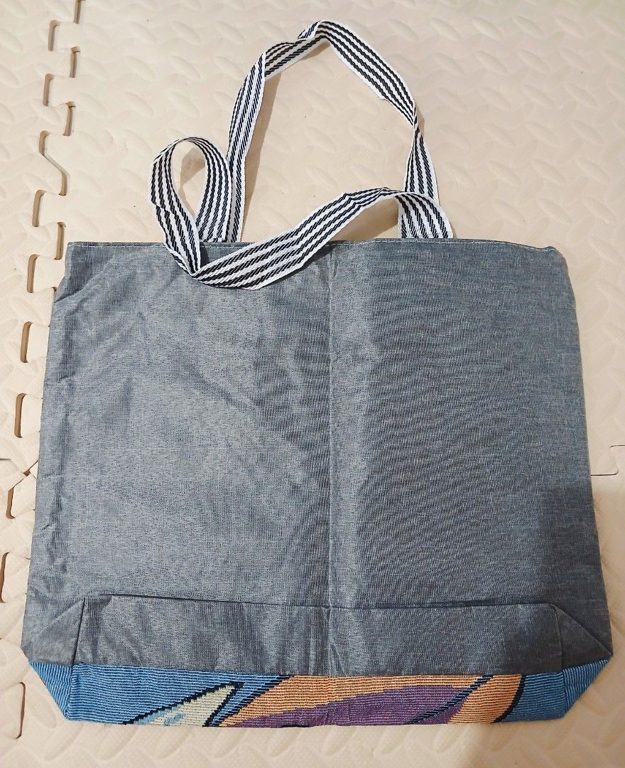 Doraemon Tote Bag (Category: Tote Bags) located in Calamba. Submitted by BraidApparel (Listing ID 1458340596, Image 2). Description: - Adorable Doraemon tote bag - Vibrant design on the front - Plain grey back - Interior zippered pocket for essentials - Striped handles for a stylish touch - Ideal for everyday use or as a thoughtful gift Location: Calamba City Laguna Deliver via J&T .
