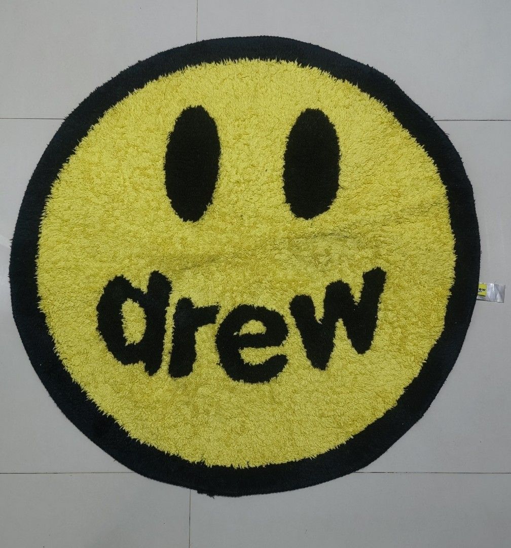 Drew House Smiley Face Rug (Category: Carpets, Mats & Flooring) located in Las Pinas. Submitted by huslerz (Listing ID 1458324182, Image 1). Description: - Yellow smiley face rug featuring the iconic Drew House logo. - Bold black outline and details for a striking look. - Luxuriously soft texture for ultimate comfort. - Equipped with a non-slip backing for safety and stability. - An ideal way to inject fun and style into any room..