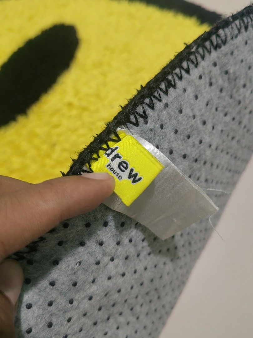 Drew House Smiley Face Rug (Category: Carpets, Mats & Flooring) located in Las Pinas. Submitted by huslerz (Listing ID 1458324182, Image 2). Description: - Yellow smiley face rug featuring the iconic Drew House logo. - Bold black outline and details for a striking look. - Luxuriously soft texture for ultimate comfort. - Equipped with a non-slip backing for safety and stability. - An ideal way to inject fun and style into any room..
