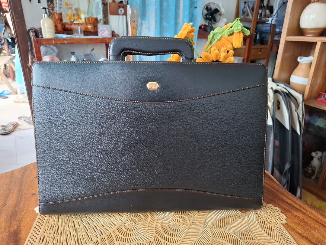 DUNHILL Black Leather Briefcase (Category: Luxury Bags & Wallets) located in Libon. Submitted by jaladzarmi80045 (Listing ID 1458350687, Image 1). Description: -not used-super excellent condition (look at the zipper still in the middle) - Classic black leather briefcase -convertible to clutchbag - Zippered compartment on the back - Multiple interior pockets for organization - Sturdy and comfortable handles - Ideal for work or travel -size: 10.5"×