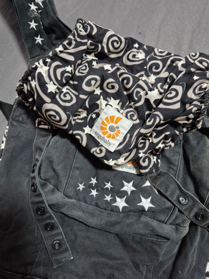 Ergobaby Baby Carrier with Star Pattern (Category: Carriers & Slings) located in Santo Tomas. Submitted by bellaswann18 (Listing ID 1458305851, Image 1). Description: - Ergobaby carrier in dark wash denim - Features white star embroidery - Includes patterned infant insert with swirls and stars - Adjustable straps and buckles for a secure fit - Perfect for keeping your baby close and comfortable - Ready for your next adventure together! - good unt