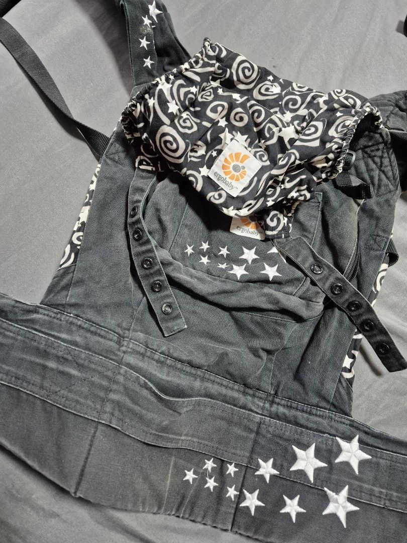 Ergobaby Baby Carrier with Star Pattern (Category: Carriers & Slings) located in Santo Tomas. Submitted by bellaswann18 (Listing ID 1458305851, Image 3). Description: - Ergobaby carrier in dark wash denim - Features white star embroidery - Includes patterned infant insert with swirls and stars - Adjustable straps and buckles for a secure fit - Perfect for keeping your baby close and comfortable - Ready for your next adventure together! - good unt