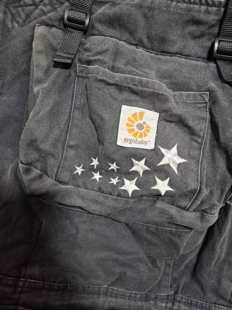Ergobaby Baby Carrier with Star Pattern (Category: Carriers & Slings) located in Santo Tomas. Submitted by bellaswann18 (Listing ID 1458305851, Image 2). Description: - Ergobaby carrier in dark wash denim - Features white star embroidery - Includes patterned infant insert with swirls and stars - Adjustable straps and buckles for a secure fit - Perfect for keeping your baby close and comfortable - Ready for your next adventure together! - good unt