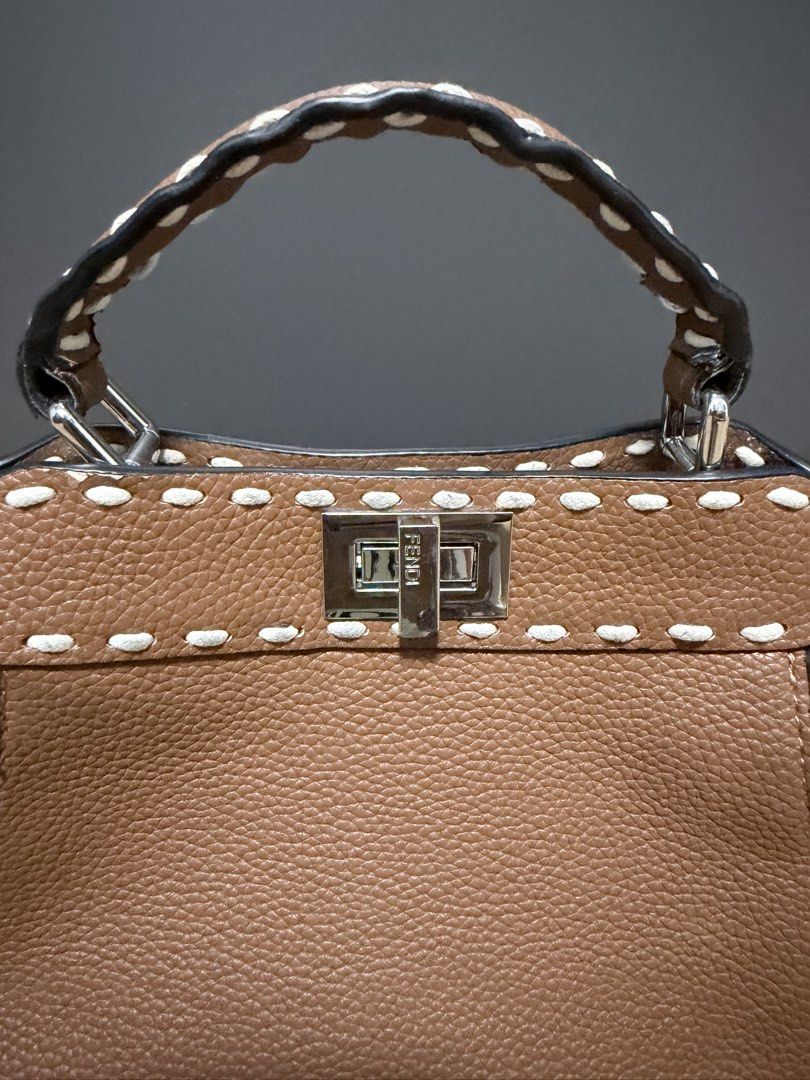 Fendi Peekaboo Bag (Category: Luxury Bags & Wallets) located in Manila. Submitted by heypreloved2016 (Listing ID 1458397351, Image 2). Description: Brown Fendi Peekaboo bag. Textured leather with white stitching detail. Silver hardware and clasp closure. Top handle and detachable shoulder strap. Includes Fendi dust bag. Great for everyday use. .