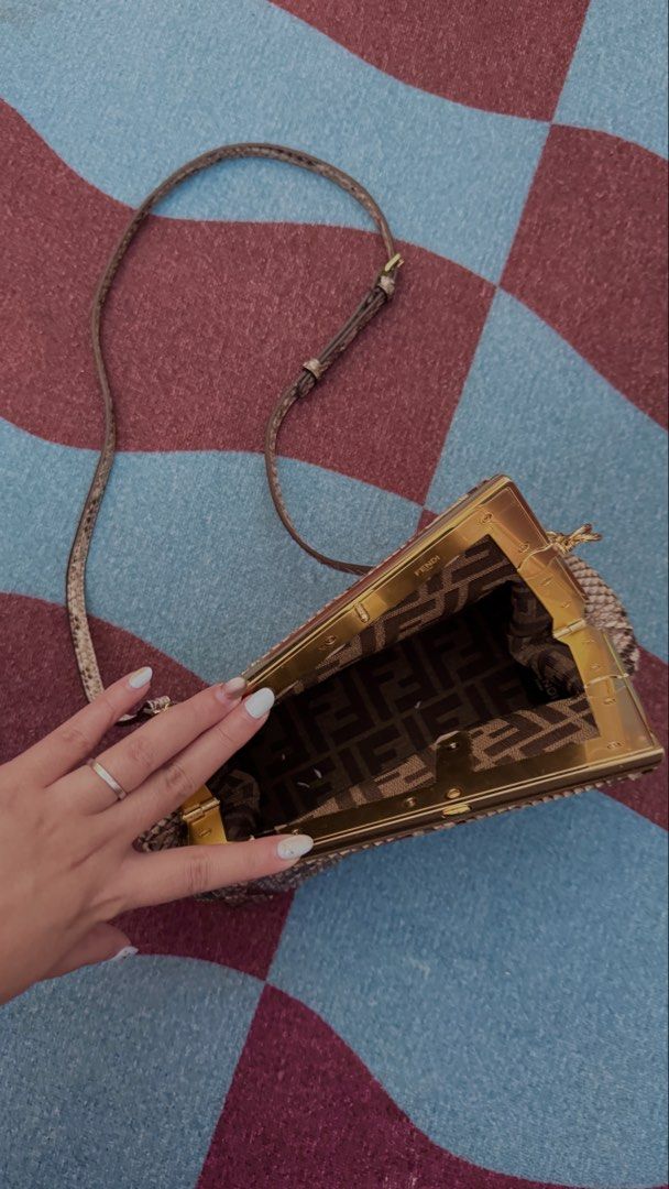 Fendi Python Clutch Bag (Category: Clutches) located in Singapore. Submitted by jkonlysellgenuine (Listing ID 1458348228, Image 3). Description: - Authentic Fendi clutch - Genuine python skin - Gold hardware frame closure - Fendi logo lining interior - Detachable strap included - Ideal for evenings out or special occasions - Unique texture and design.